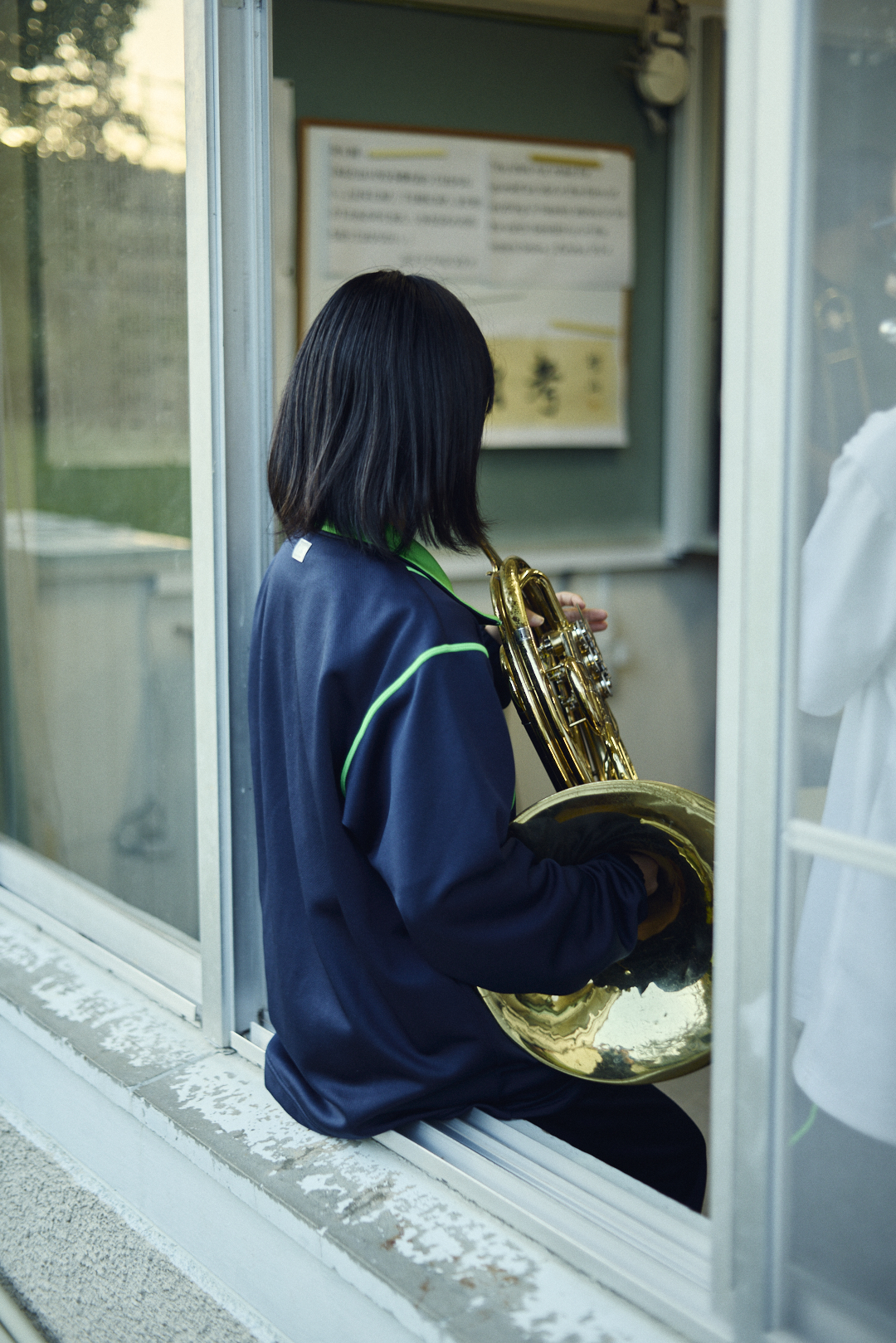 校舎の前で楽器を持つ生徒たち