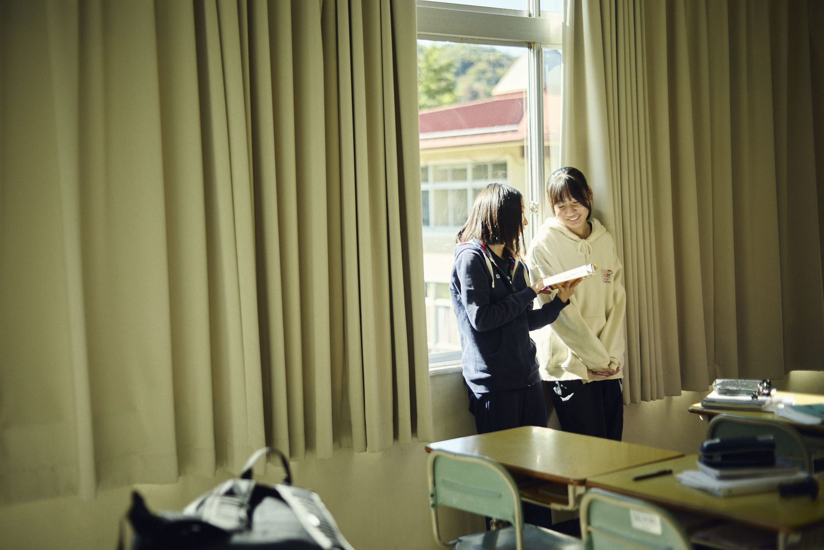 外のテーブルで会話する生徒たち